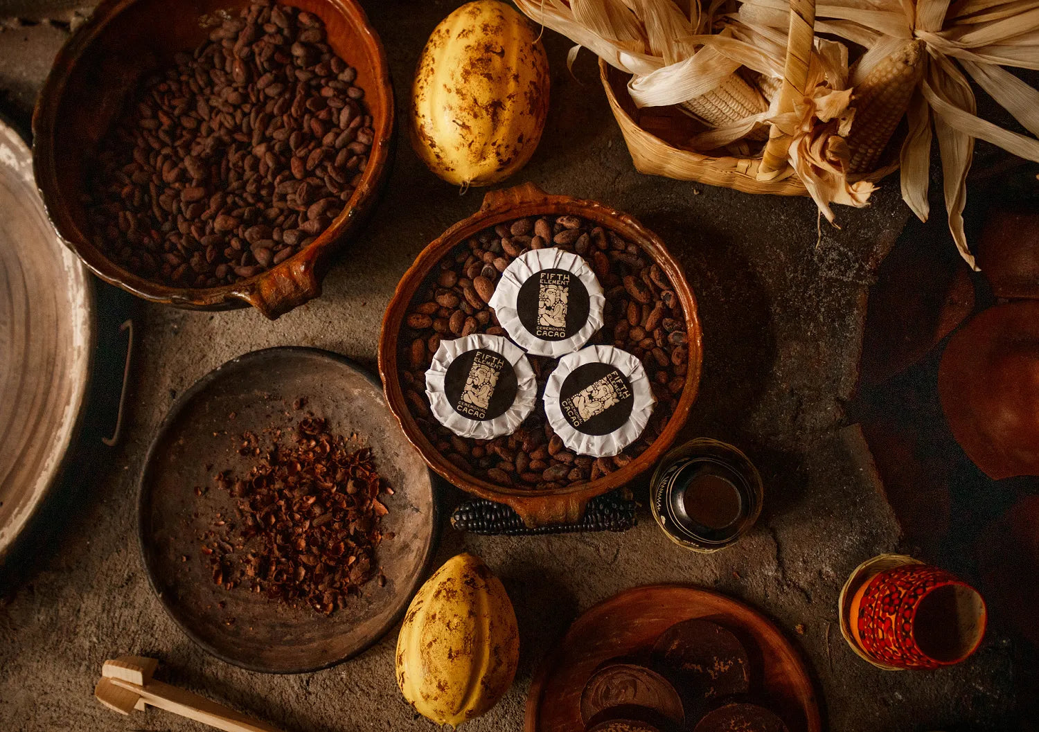 Ceremonial Cacao in a clay bowl placed on roasted cacao beans on a table.